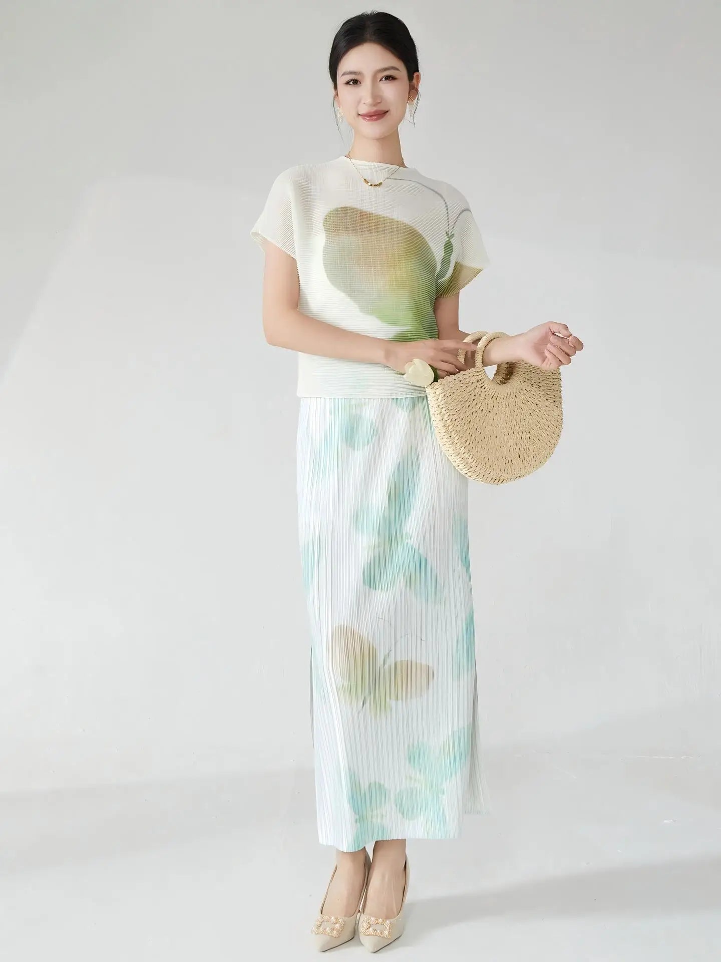 Summer women's outfit: a stylish two-piece set including a short-sleeved T-shirt and a pleated midi skirt with a slit.