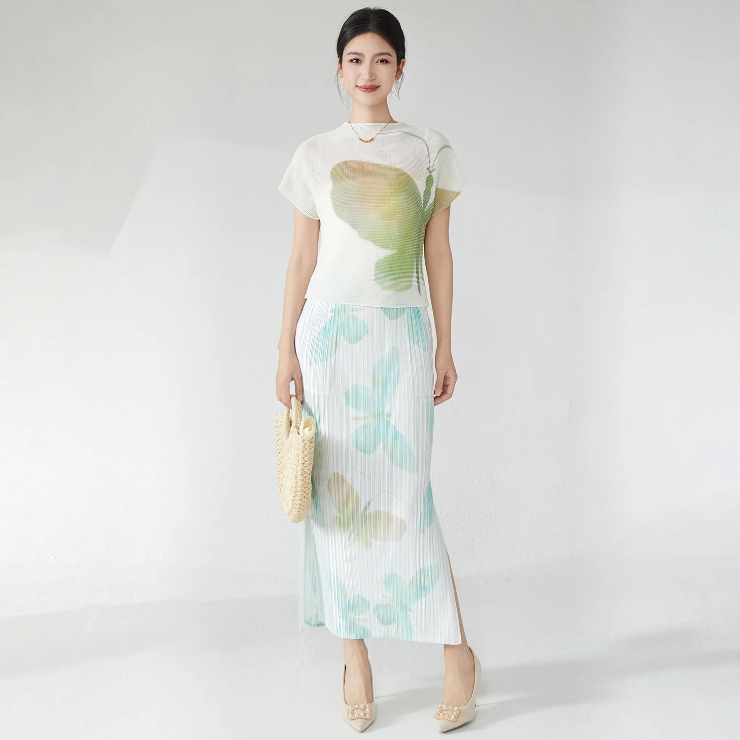 Summer women's outfit: a stylish two-piece set including a short-sleeved T-shirt and a pleated midi skirt with a slit.